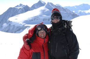 Two Test Your Limit team members posing for a photo in front of a mountain.