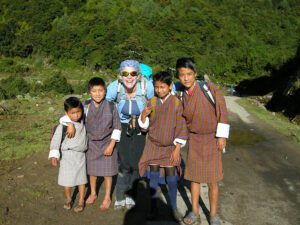 Five people in Bhutan posing for a photo in front of trees.