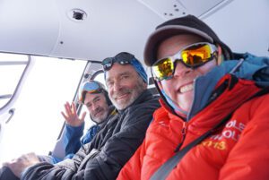 People posing for a photo in a vehicle.