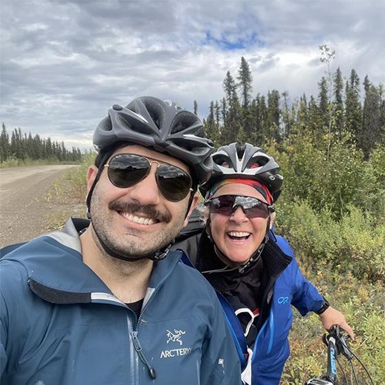 Farid Foroutan and Dr. Ross standing on the side of the road wearing bicycle helmets.