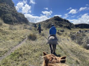 The Test Your Limits team horseback riding through the mountains.